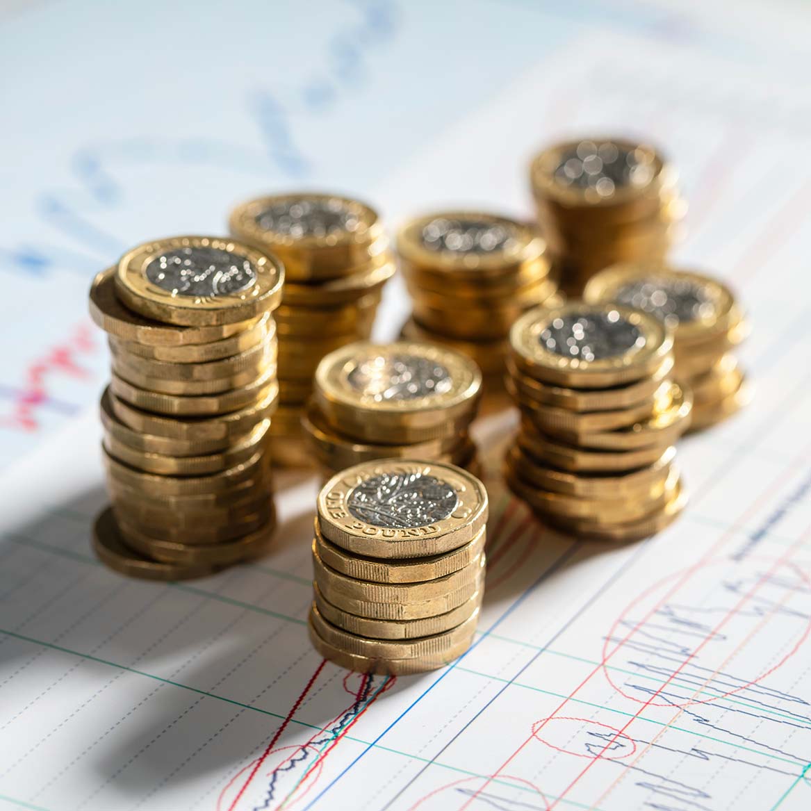 Pound coins stacked next to each other on a piece of paper